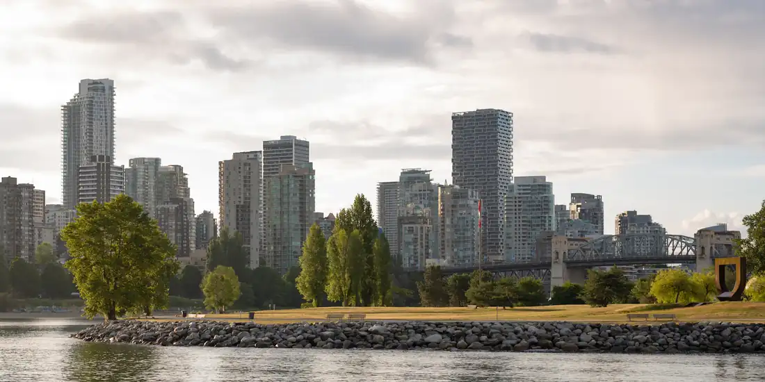 Downtown Vancouver towers seen across the water from a waterfront park